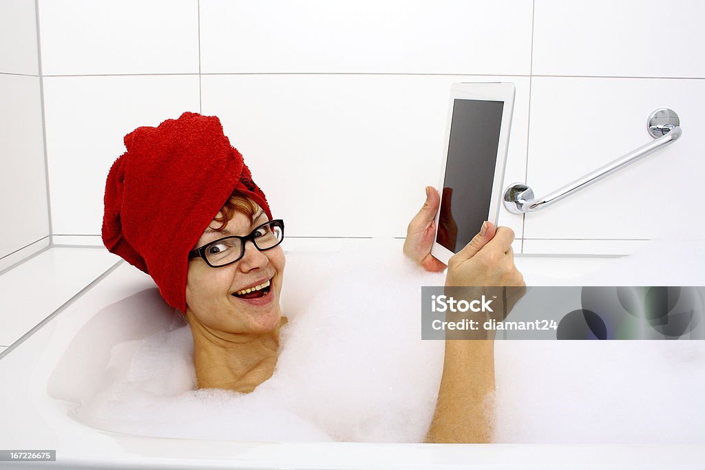 Enthusiastic woman in bathtub with tablet computers Enthusiastic woman in bathtub with tablet computers, close up Bathtub Stock Photo