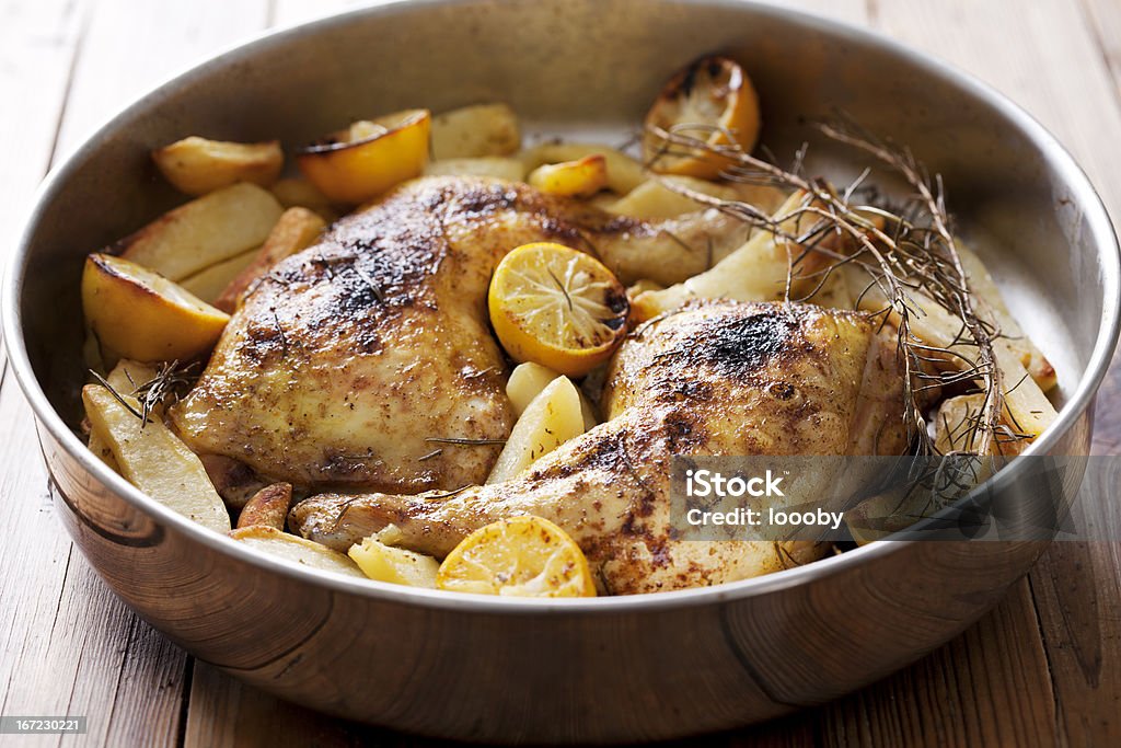 chicken roast chicken legs,cooked with rosemary, lemon and potatoes Lemon - Fruit Stock Photo