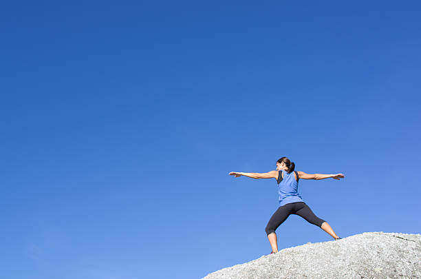 Young woman practicing youga outdoors in the mountains.