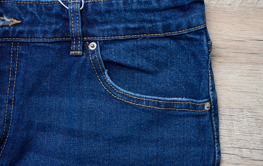 Blue jeans front pocket with buttons, close up