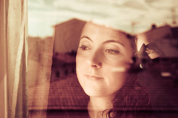 istock Young woman looking out window 167234474