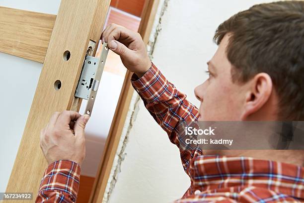Carpenter At Door Lock Installation Stock Photo - Download Image Now - Adult, Adults Only, Blue-collar Worker
