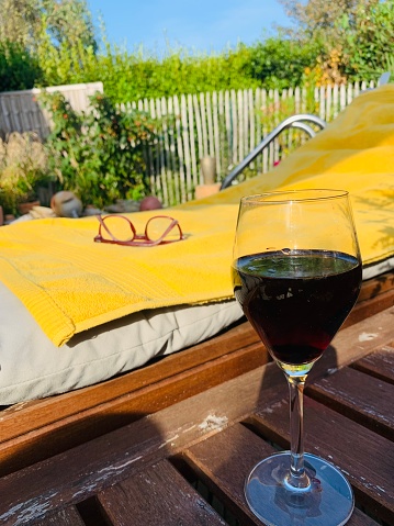 Deckchair, baht towel and glass of red wine