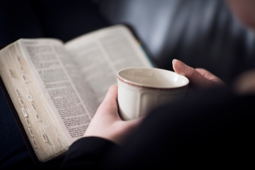 Mujer lee la Biblia y beber té o café photo