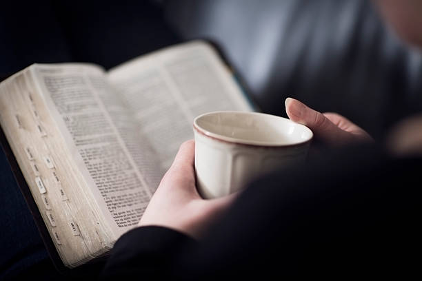 donna lettura della bibbia e bere tè o caffè - bibbia foto e immagini stock