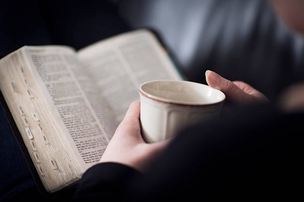 woman read the bible and drink tea or coffee - bijbel stockfoto's en -beelden