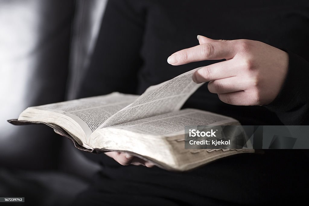 Woman sits in a sofa and read the Bible A close-up of a christian woman reading and study in the bible.  Bible Stock Photo