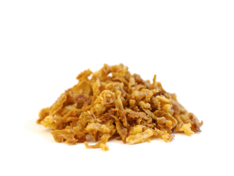 A heap / pile of fried onion on white background.