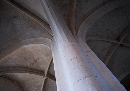 old pillar in catholic french village church with arched ceilings above