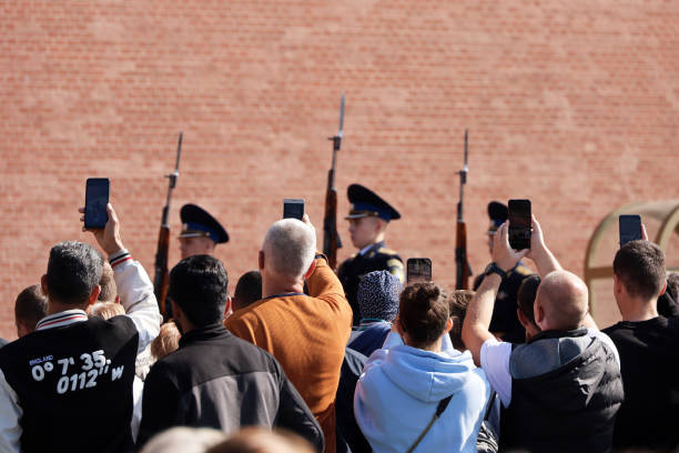 クレムリンの壁の近くを行進する観光客とロシアの兵士 - tourist photographing armed forces military ストックフォトと画像