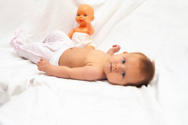 Infant baby with a baby doll.