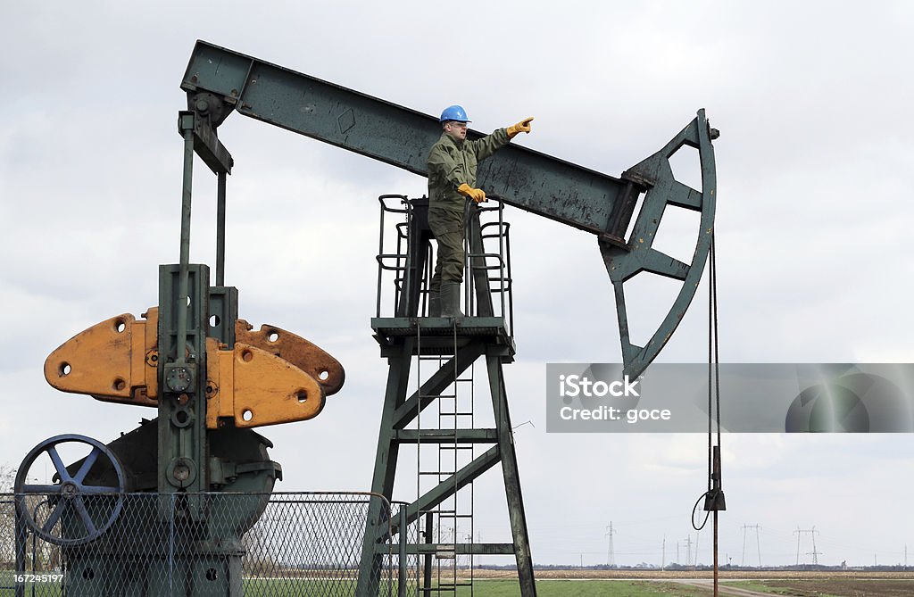 oil worker stands at the pump jack Oil Worker Stock Photo