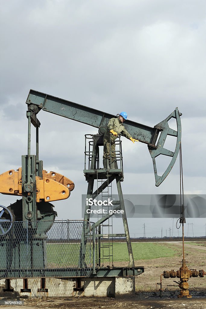 Trabajador y oilfield con bomba jack - Foto de stock de Accesorio de cabeza libre de derechos