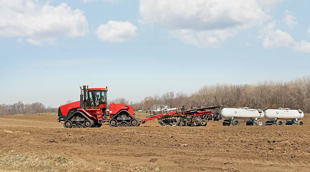 Plowing and Fertilizing Tractor pulling plow and anhydrous ammonia tanks ammonia fertilizer stock pictures, royalty-free photos & images
