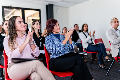 Audience applauding a presentation on a meeting at office