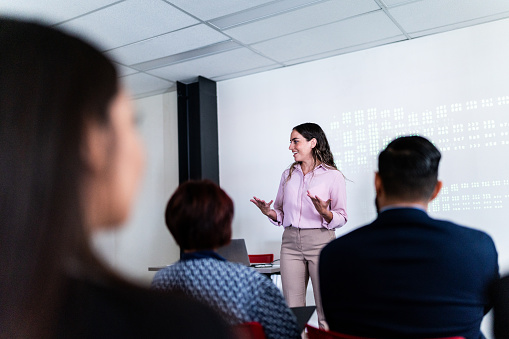 Mid adult woman doing a presentation on a meeting at office