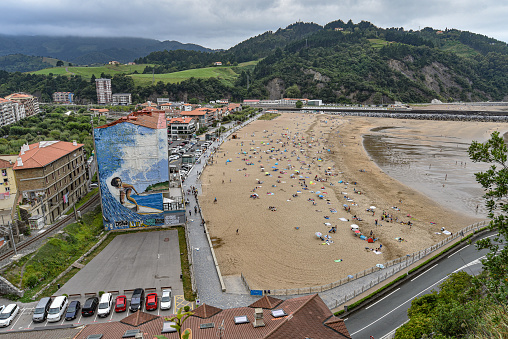 Deba, Spain - 14 August 2021: Crowds enjoy the summer sun on the beaches of Deba, Basque Country, Spain