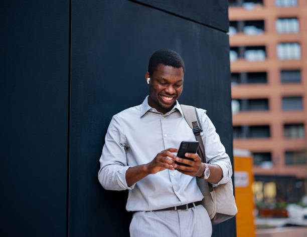 istock A Happy Handsome Businessman With Earbuds Watching Something On His Mobile Phone While Standing On The Street 1672556541