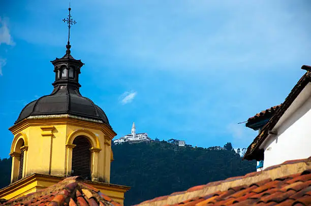 A yellow church in Bogota with Monserrate in the background.