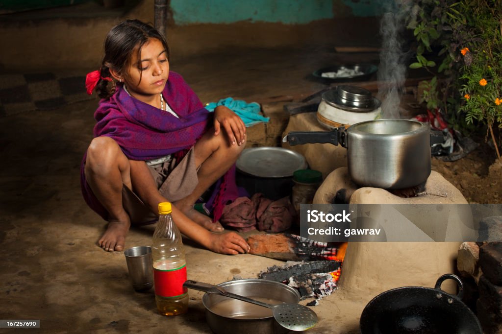 Pauvre fille indienne cuisine cuisson dans un four d'argile - Photo de Travail des enfants libre de droits