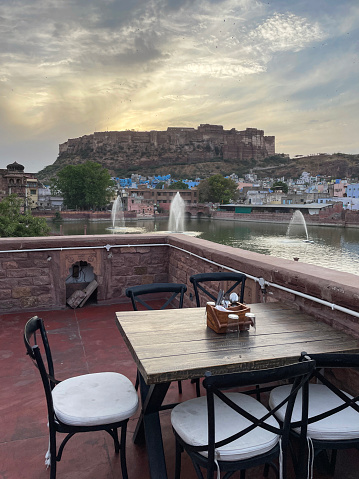 Stock photo showing Jodhpur's Mehrangarh Fort and Old Quarter rooftop cityscape a a backdrop to Gulab Sagar Lake and fountains. The buildings in the city's Old Quarter are painted an almost uniform blue, as to why? Nobody can agree on a reason.