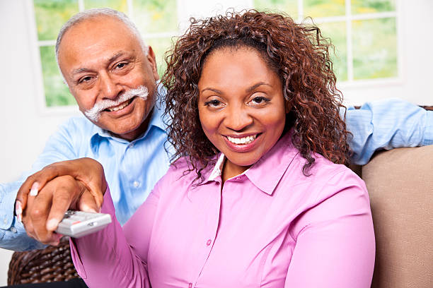 istock Relationships: Couple watching TV, both have hands on remote control 167262541