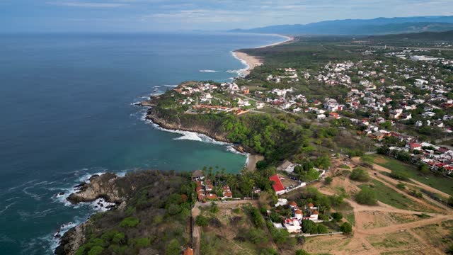 Above the coastline houses, aerial view of Carrizalillo and Bacocho beaches at Puerto Escondido, Oaxaca, Mexico