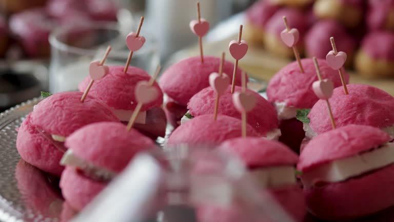 A nice sweet table; macarons, small snacks, sandwiches, pink hamburgers, sweets, cookies, cupcakes. A decorated bridal prep room table, Dessert corner, Candy Bar Wedding, Candy buffet, delicious Candy bar at a wedding