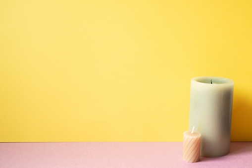 Aromatic candle on pink table. yellow background. copy space