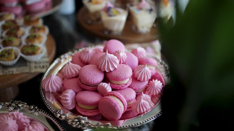 A nice sweet table; macarons, small snacks, sandwiches, pink hamburgers, sweets, cookies, cupcakes. A decorated bridal prep room table, Dessert corner, Candy Bar Wedding, Candy buffet, delicious Candy bar at a wedding