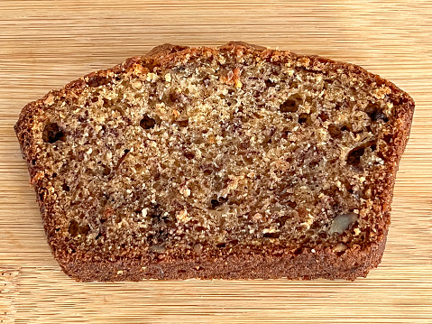 A slice of Banana bread on a wooden background, close up, top view