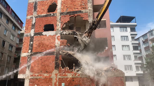 Demolition of brick walls with excavator, Old building and debris, a construction equipment is trying to demolish the old building, Demolition of a building with concrete floors and pillars