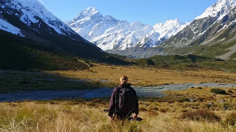 Young man with backpack and photography gear on a journey into the mountains