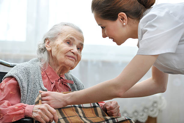 istock Smiling caregiver helping senior woman with blanket 167280430