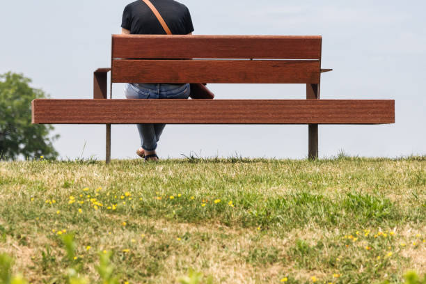 istock a person sits on a bench on a dike 1672805574