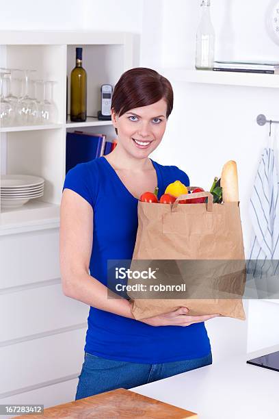 Foto de Mulher Com Saco De Compras Na Cozinha e mais fotos de stock de Adulto - Adulto, Alimentação Saudável, Beleza