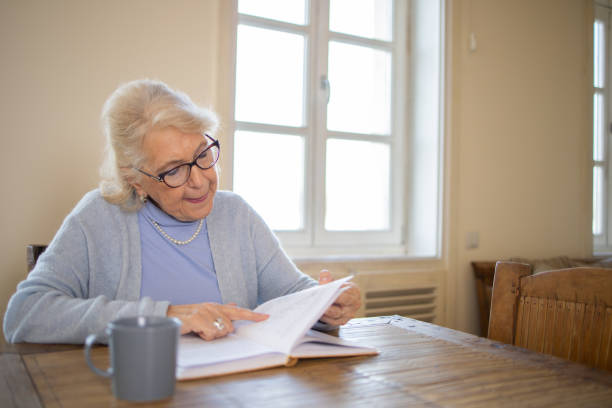 istock Woman reading book at home 1672860145