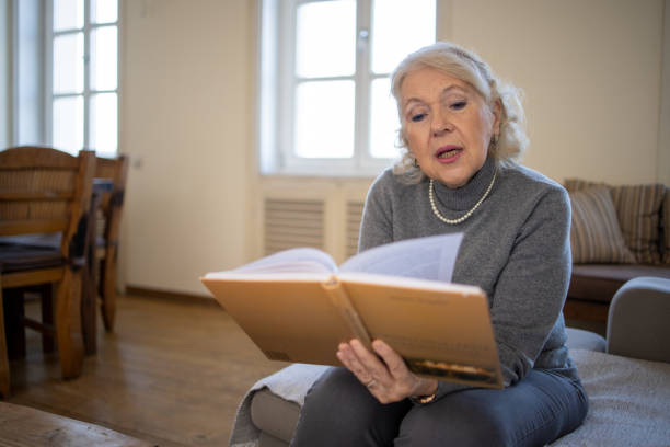 istock Woman reading book at home 1672860157