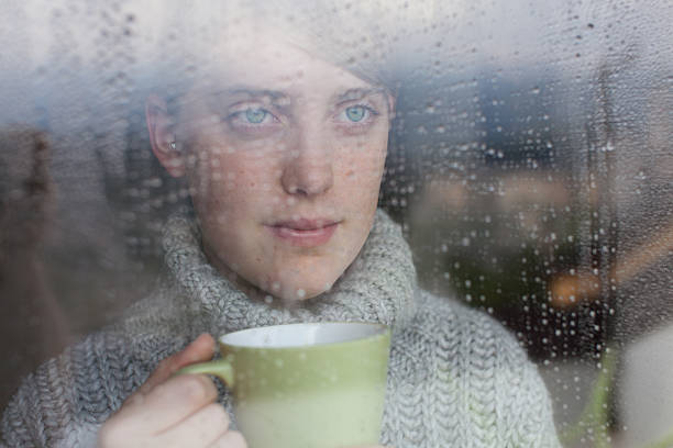istock Young girl looks at rain through the window 167286512