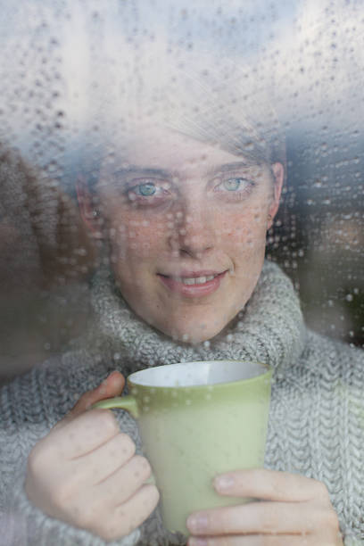 istock Young girl looks at rain through the window 167286519