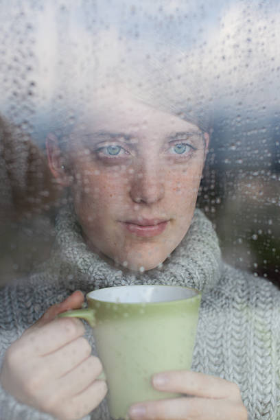 istock Young girl looks at rain through the window 167288422