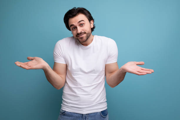 istock doubtful guy in a white T-shirt throws up his hands 1672904556