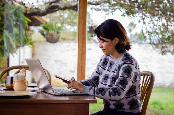 istock woman using a laptop and smartphone on a table 1672931452