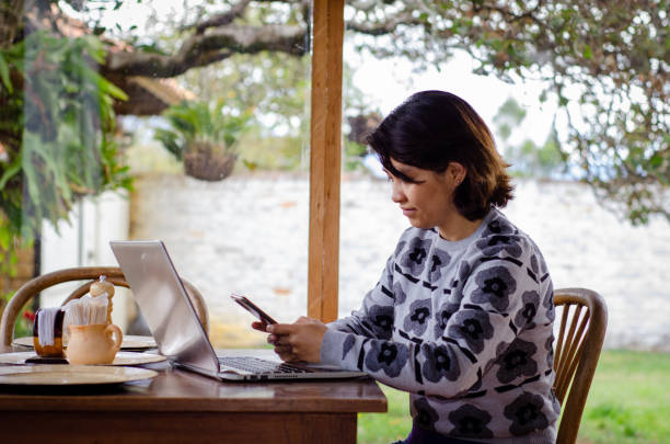 istock woman using a laptop and smartphone on a table 1672931822