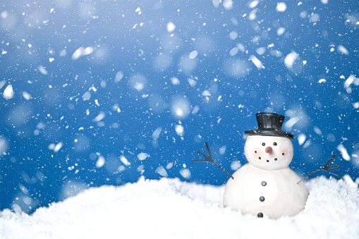 Snowman in the snow. Winter storytelling, can be used for holiday greeting cards, postcards, invitations, advertising, marketing. Single snowman snow snow and dark blue background. Copy space. Not AI