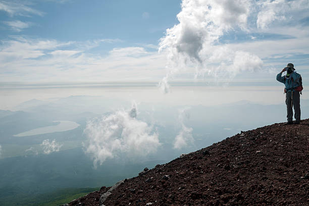 wolken formation - behind photographer men mountain climbing stock-fotos und bilder