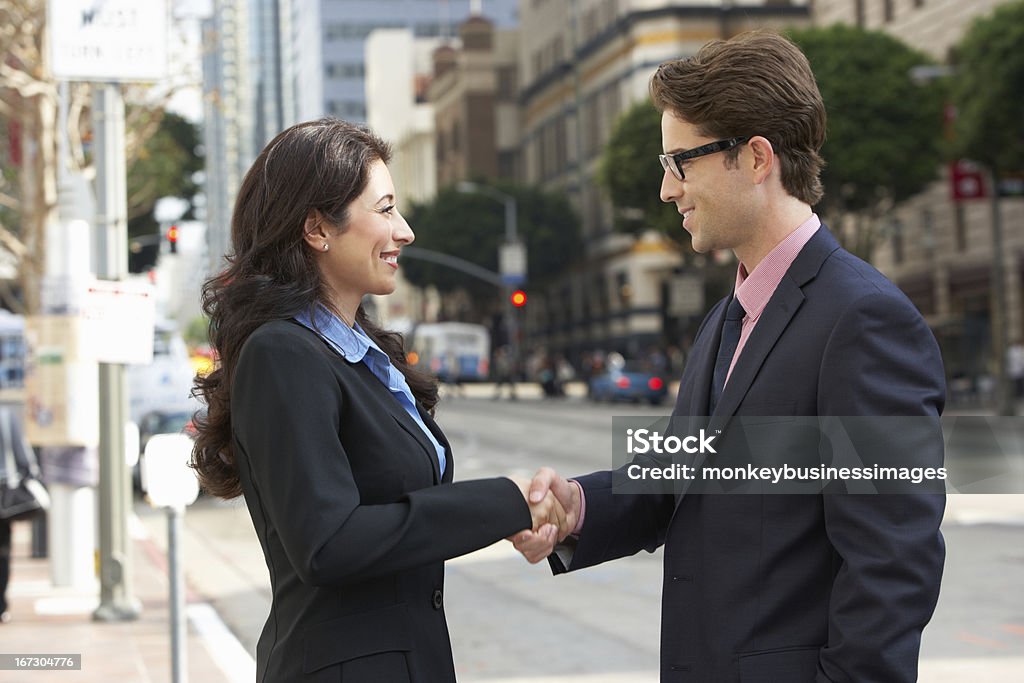 Empresário e Mulher de negócios, apertando as mãos "na rua - Foto de stock de Dar as Mãos royalty-free