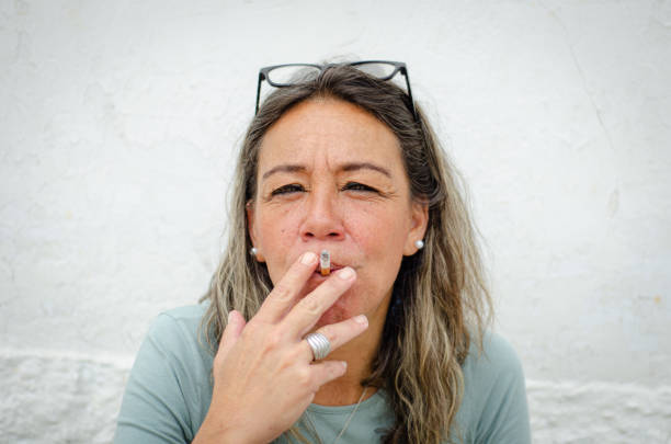 portrait of middle aged woman smoking stock photo