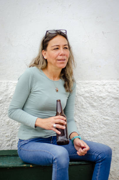 portrait of middle aged woman drinking beer stock photo