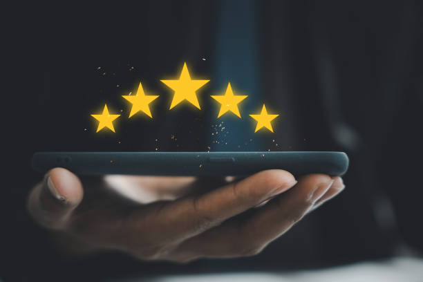 istock Close-up of man's hand using smartphone to rate service with 5-star feedback icon 1673084206